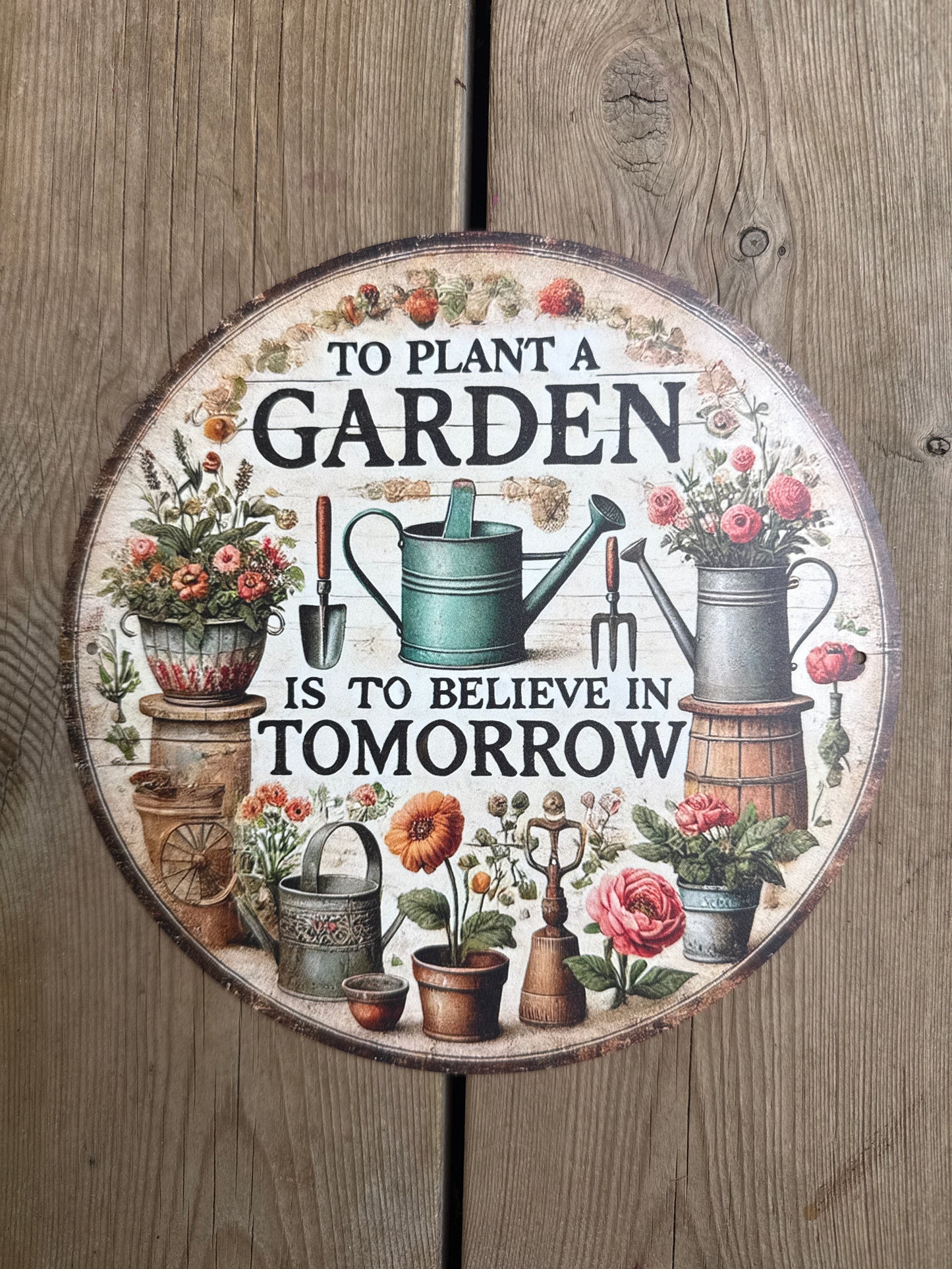 Rundt metallskilt – "To Plant a Garden Is to Believe in Tomorrow"