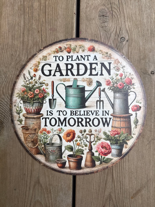 Rundt metallskilt – "To Plant a Garden Is to Believe in Tomorrow"